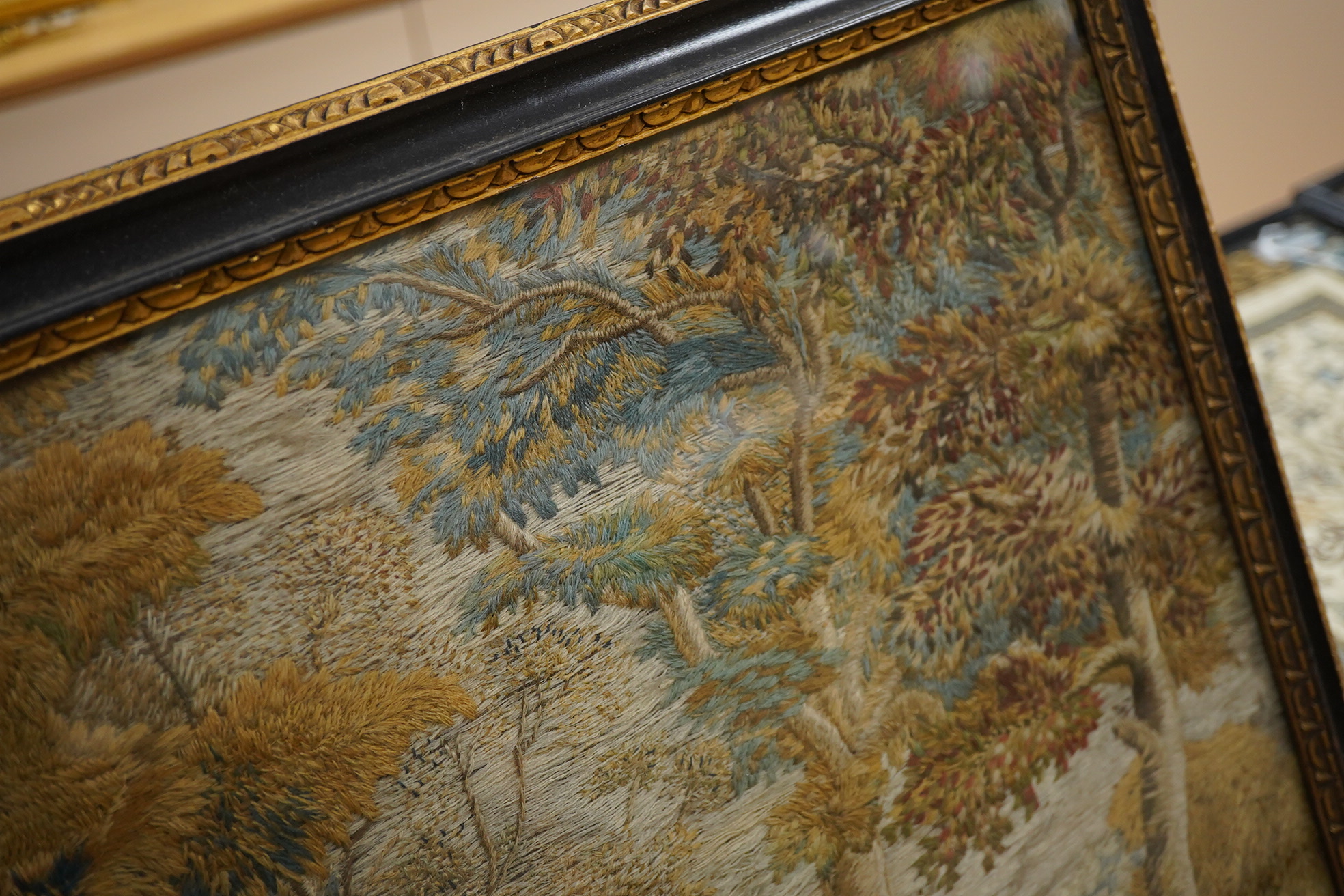 A 19th century heavily embroidered wool work of a figure and dog in a wooded landscape - 38cm x 33cm, together with smaller wool work of figures by a house. Condition - both are still strong in colour without damage.